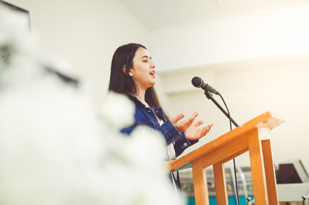 Young woman speaks at pulpit